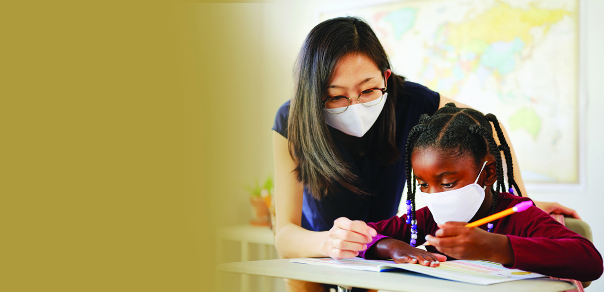 An Elementary School Student and Teacher in a Classroom